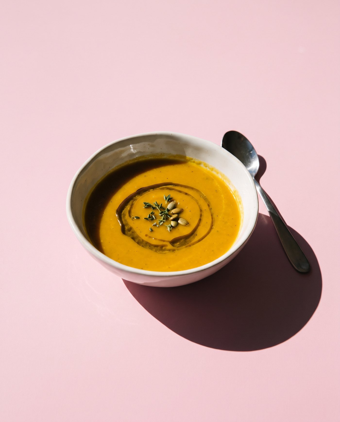 A bowl of warm soup with a swirl of olive oil